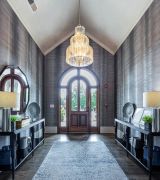 The Grove at Stone Park apartment homes with A grand entryway with double doors, a large chandelier, side tables, and a gray rug.